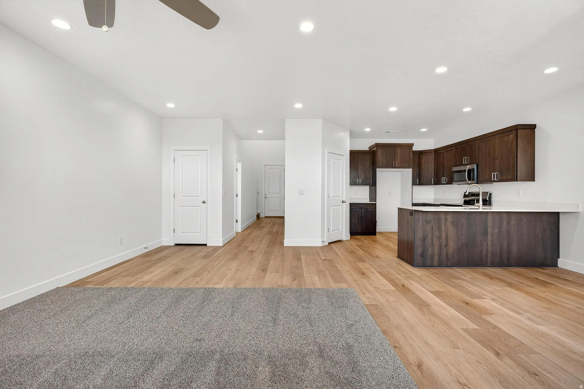 Open concept living space featuring wood-finish flooring, recessed lighting, and a modern ceiling fan