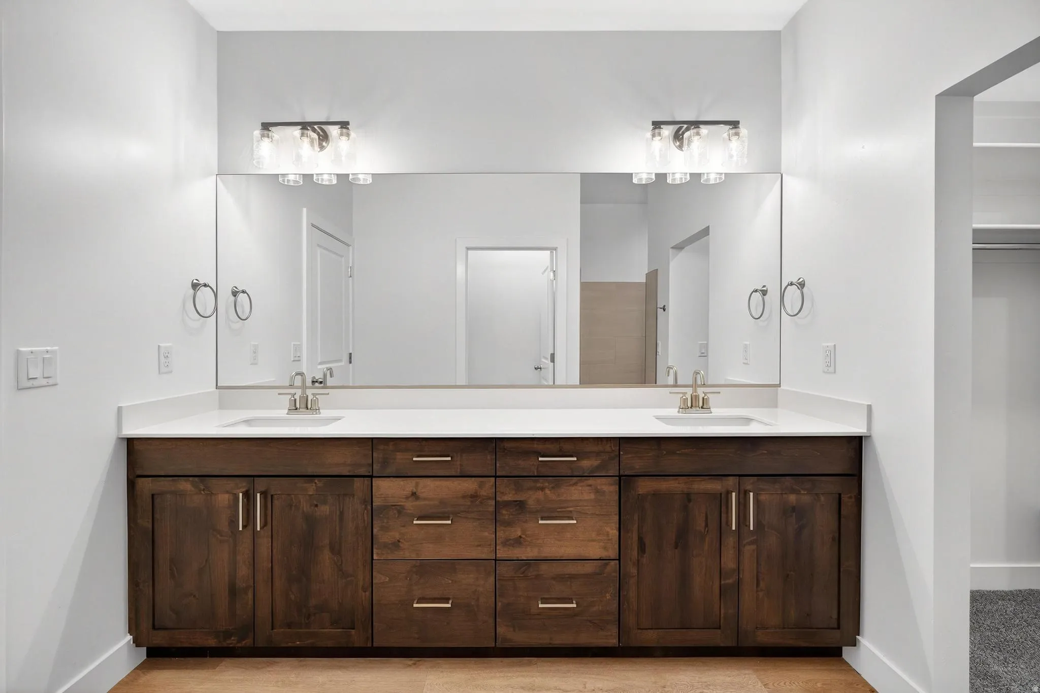 Dual vanity featuring a white countertop, two undermount sinks, and brushed nickel faucets
