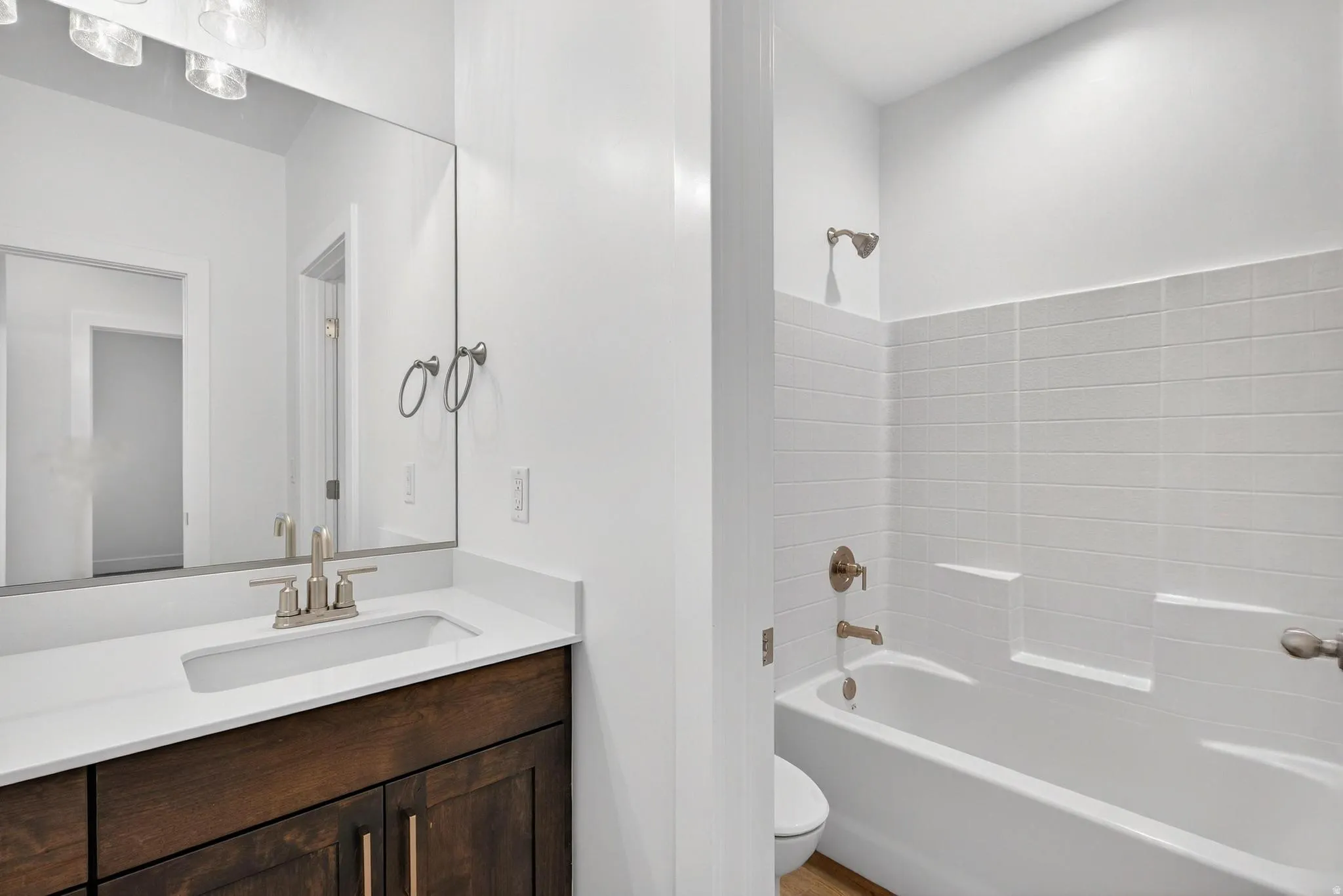 Bathroom featuring a built-in vanity with dark wood-finish cabinetry, a white countertop, and an integrated sink with a brushed nickel faucet