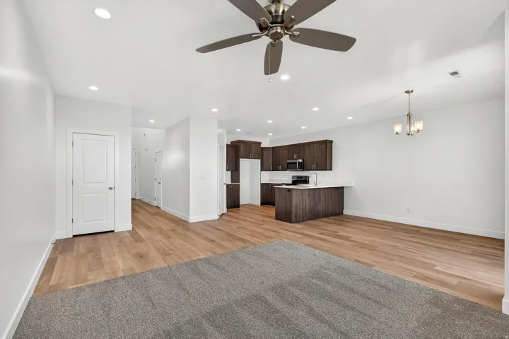 Open-concept living space featuring wood-finish flooring, recessed lighting, and a ceiling fan