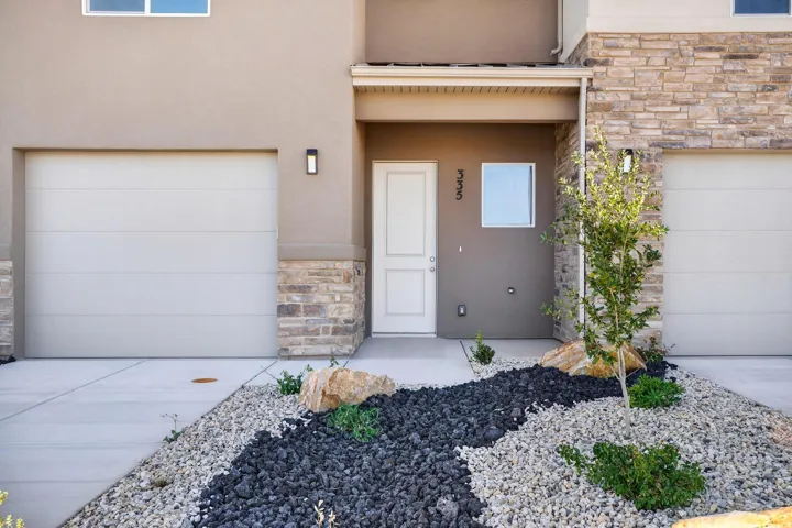 Contemporary exterior facade featuring stacked stone accents and stucco finishes