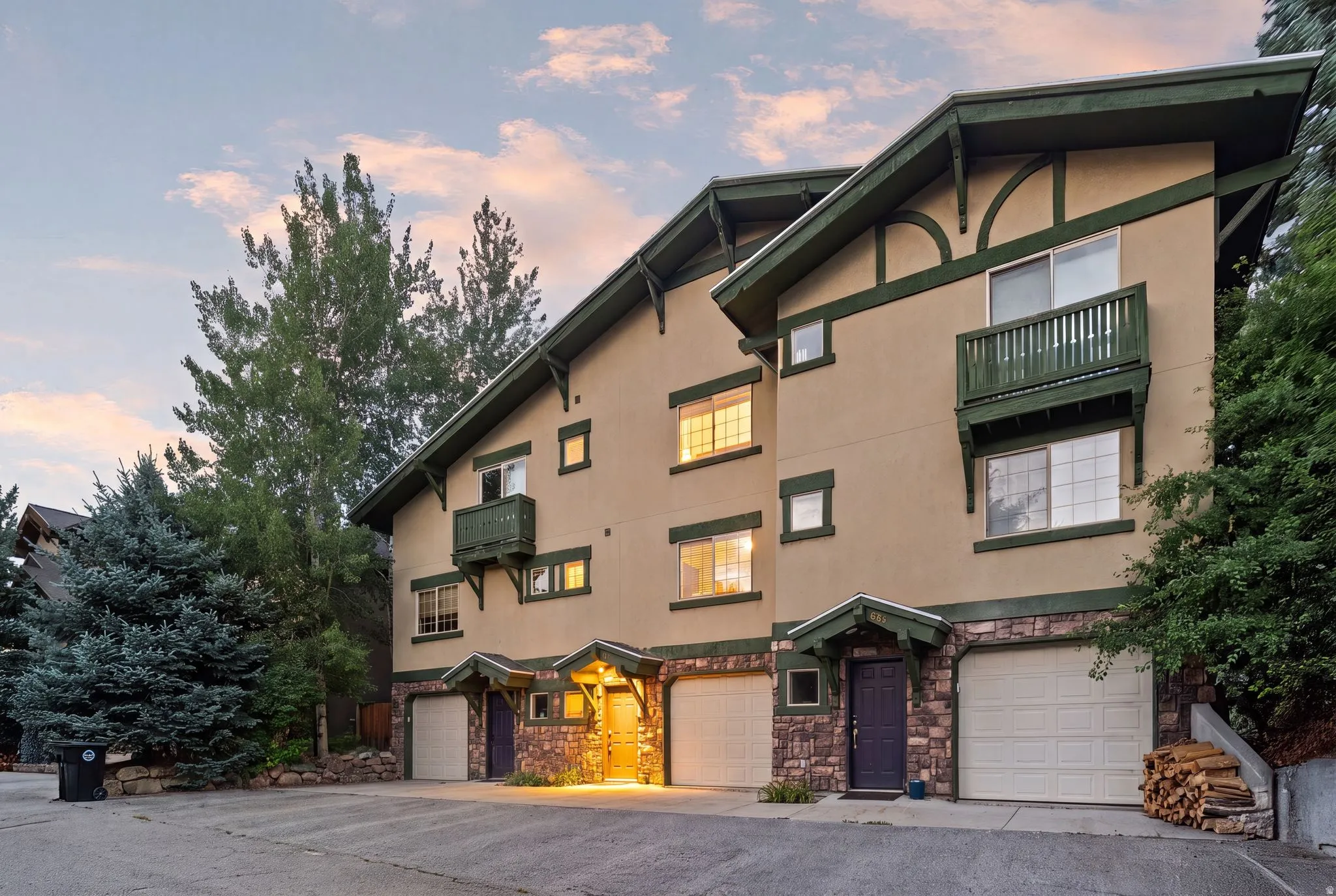 Multi-level residential building featuring stucco siding and stone veneer accents