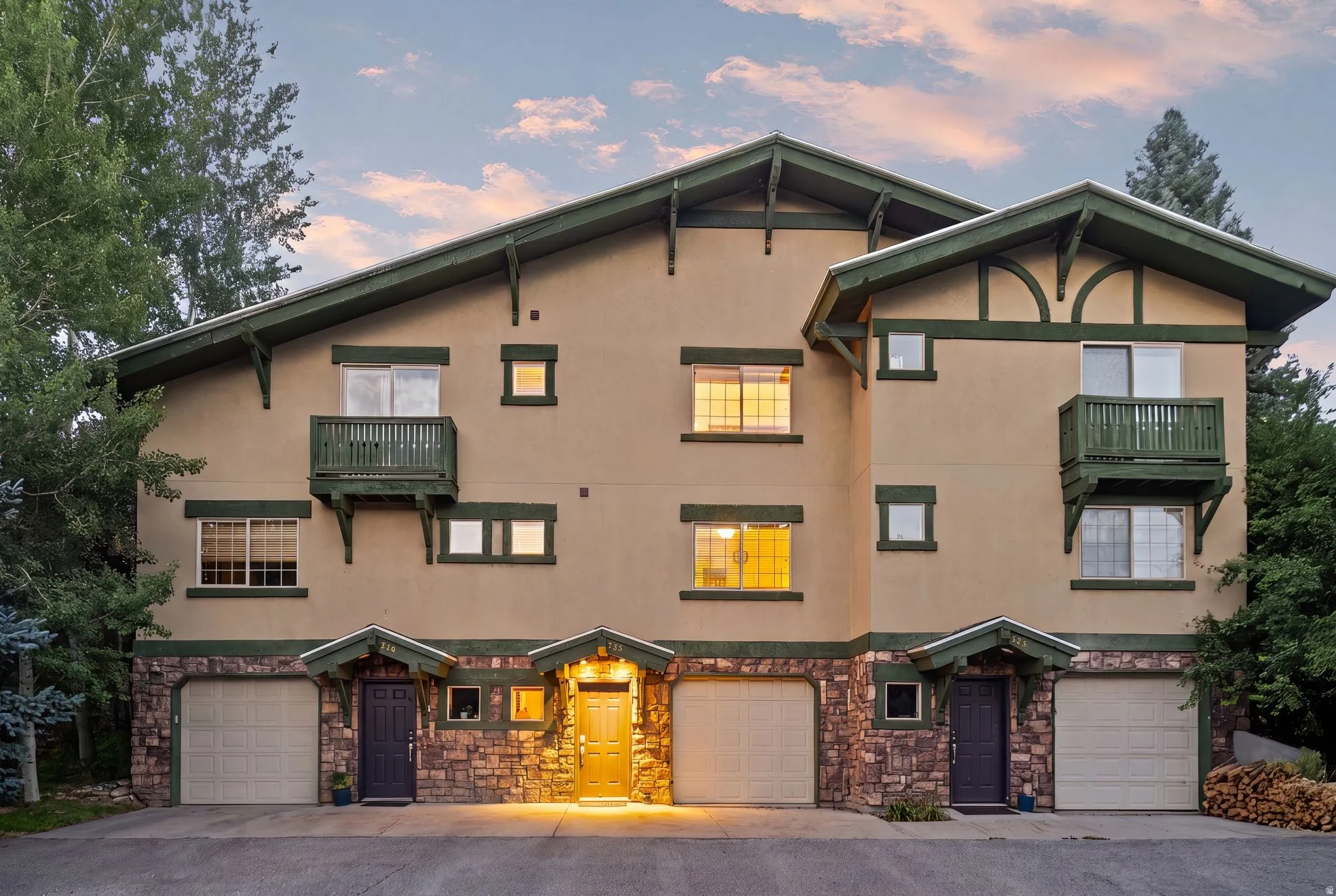 Multi-level stucco exterior with stone accents and a dark green trim