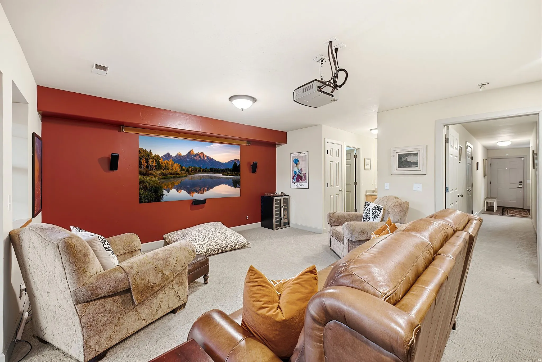Dedicated media room featuring a large projection screen, ceiling-mounted projector, and integrated wall speakers