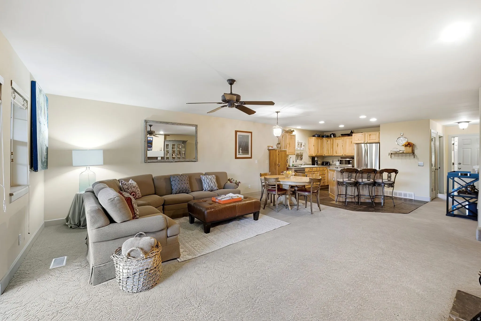 Expansive open-concept living area featuring light-toned carpeting and neutral wall tones
