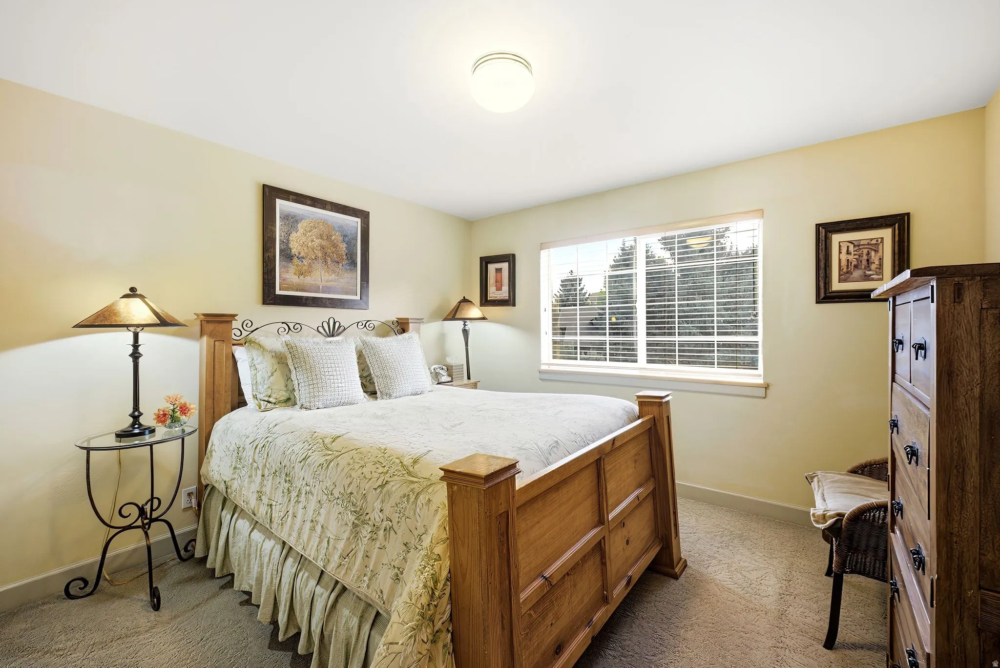 Bedroom featuring a window with blinds, light tan walls, and carpet flooring