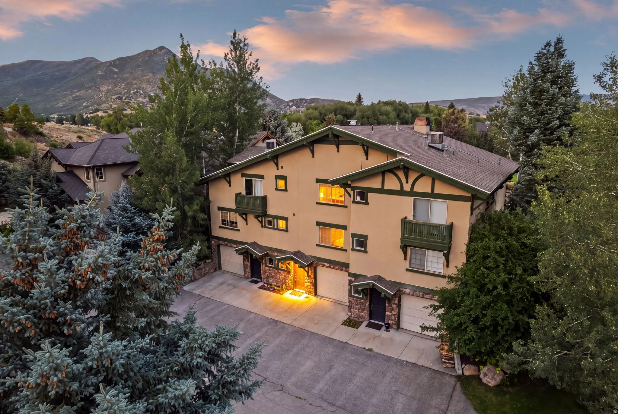 Multi-level residence featuring a stucco exterior with dark green trim accents