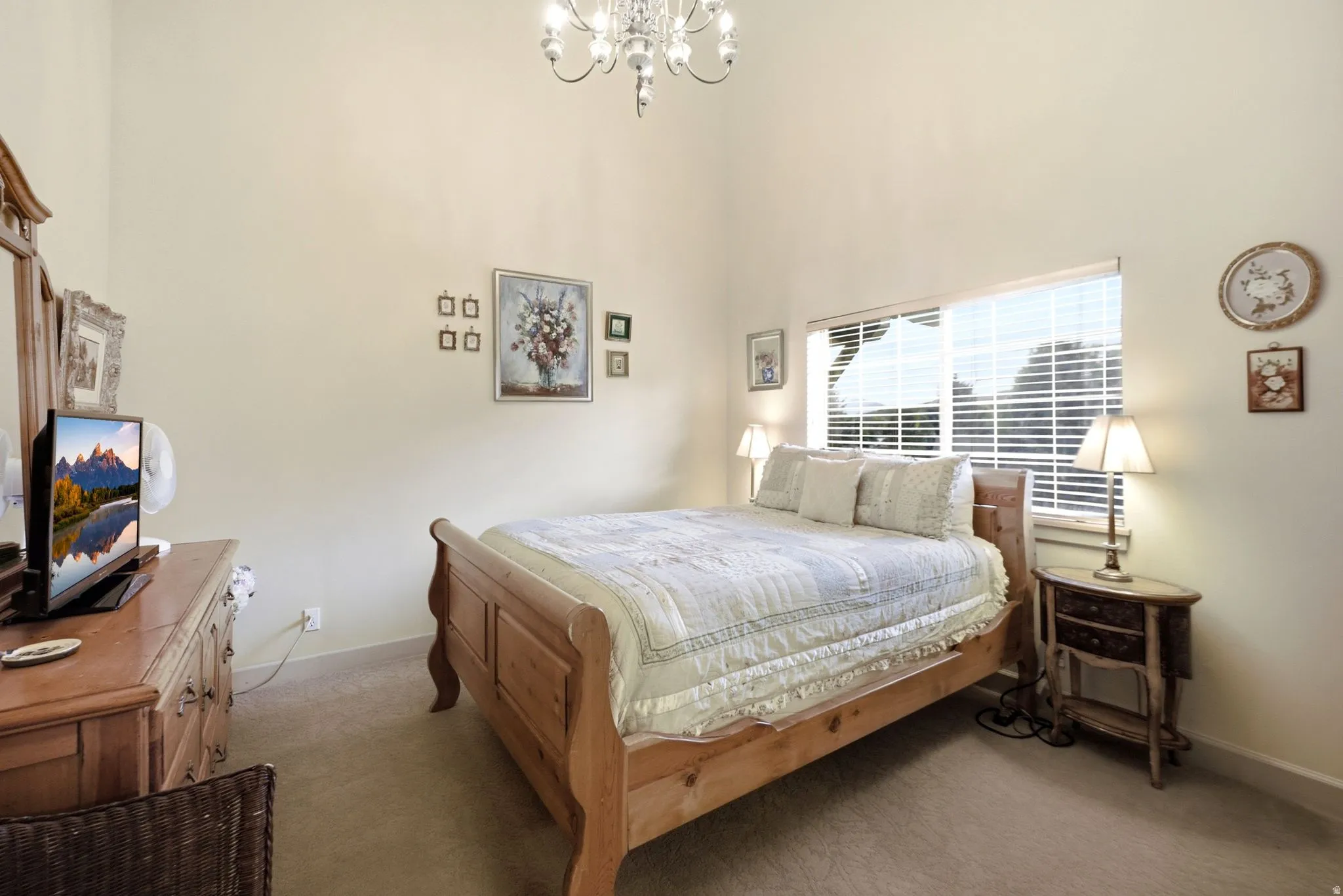 Room with vaulted ceiling, featuring a window with horizontal blinds, neutral wall paint, and carpeted flooring