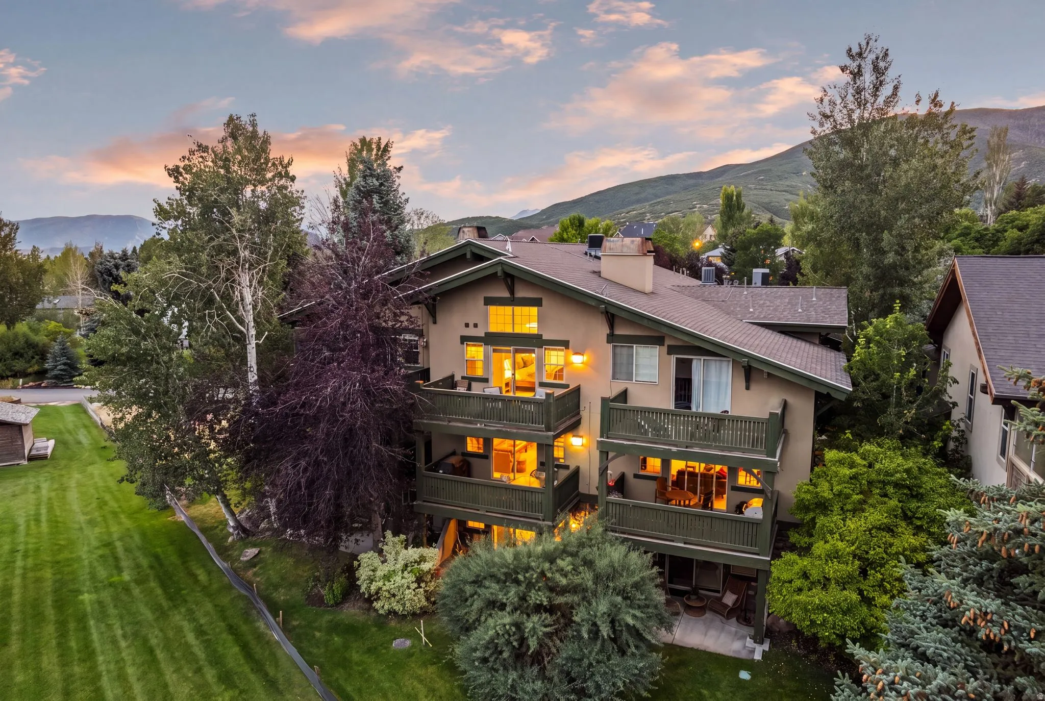 Multi-story residence featuring a neutral-toned facade, dark trim, and multiple balconies