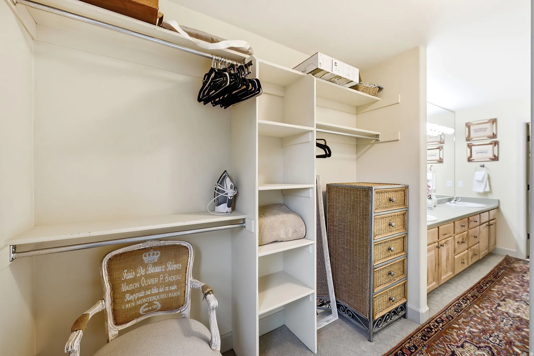 Expansive walk-in closet featuring multiple shelving units and garment rods