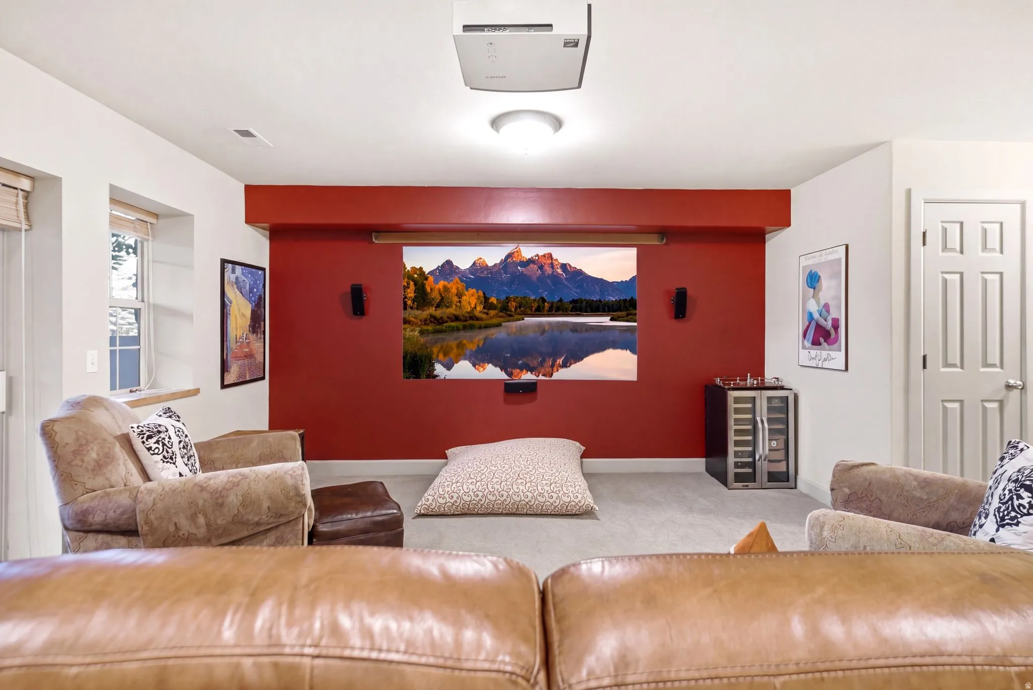 Dedicated media room featuring a projector and large projection screen