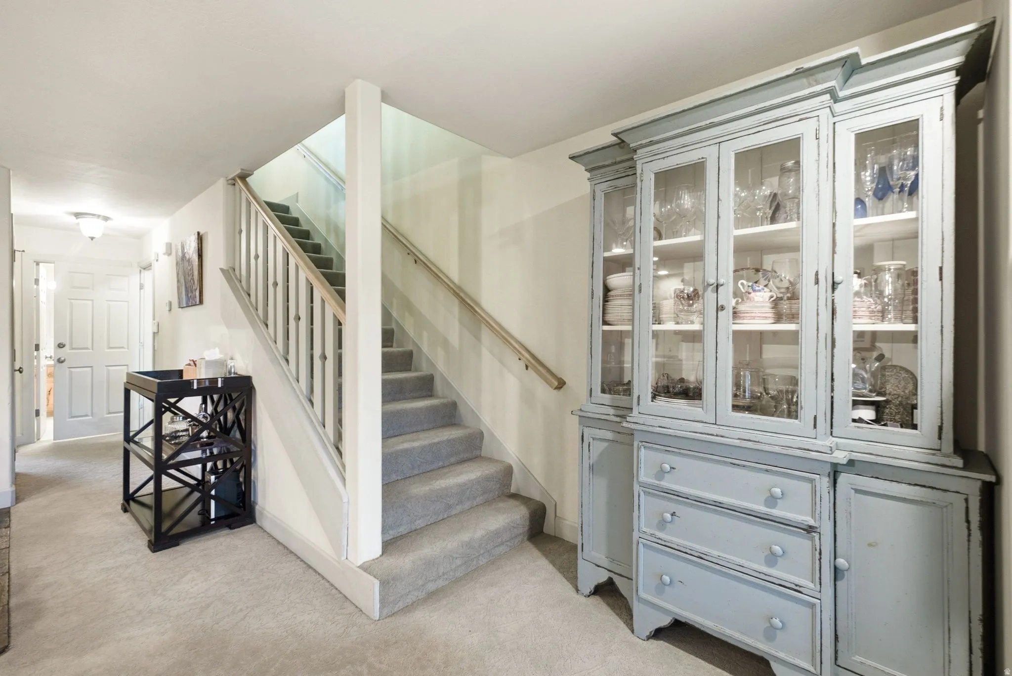 Carpeted staircase with white balusters and wood handrail