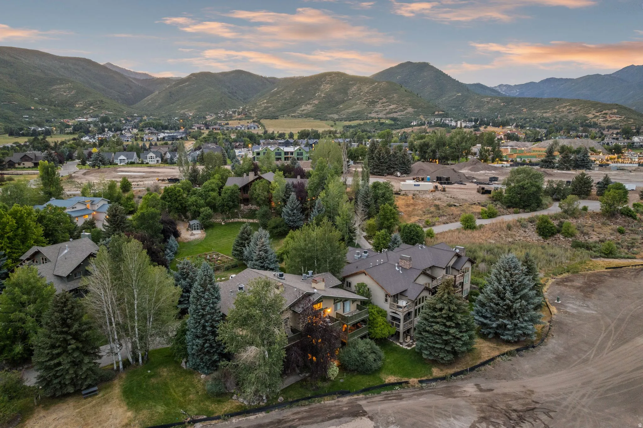 Expansive property featuring mature trees and established landscaping, surrounded by mountainous terrain