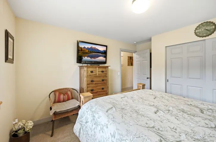 Bedroom featuring light beige wall paint, white trim, recessed ceiling light fixture, and a light-colored carpeted floor