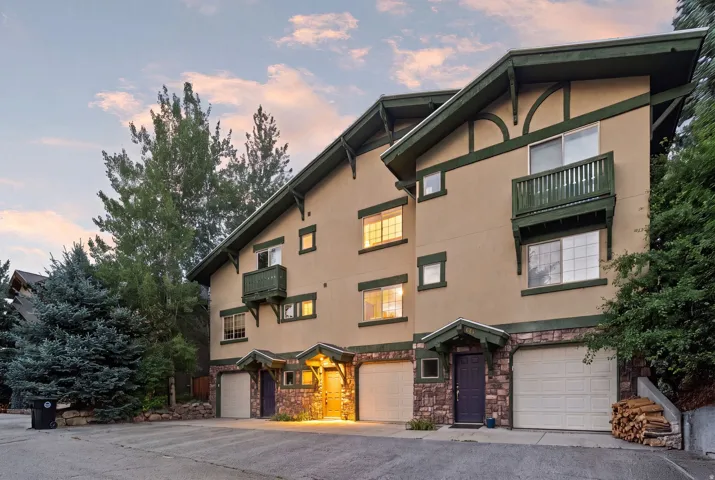 Multi-level residential building featuring stucco siding and stone veneer accents