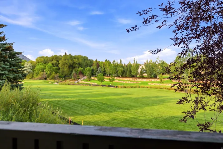 Expansive green landscape with mature trees and tiered stone retaining walls