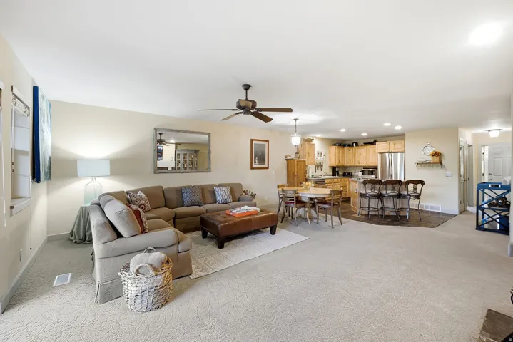Expansive open-concept living area featuring light-toned carpeting and neutral wall tones