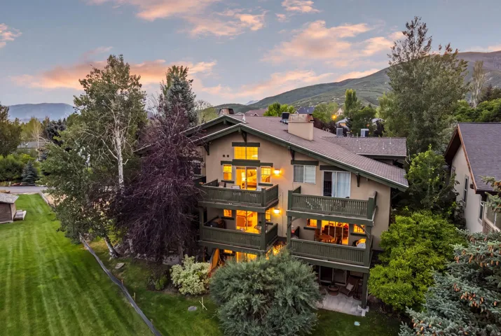 Multi-story residence featuring a neutral-toned facade, dark trim, and multiple balconies