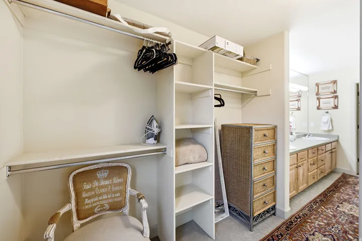 Expansive walk-in closet featuring multiple shelving units and garment rods