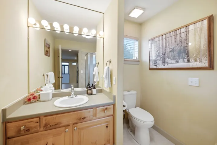 Bathroom vanity featuring a light-toned countertop with an integrated sink and chrome faucet