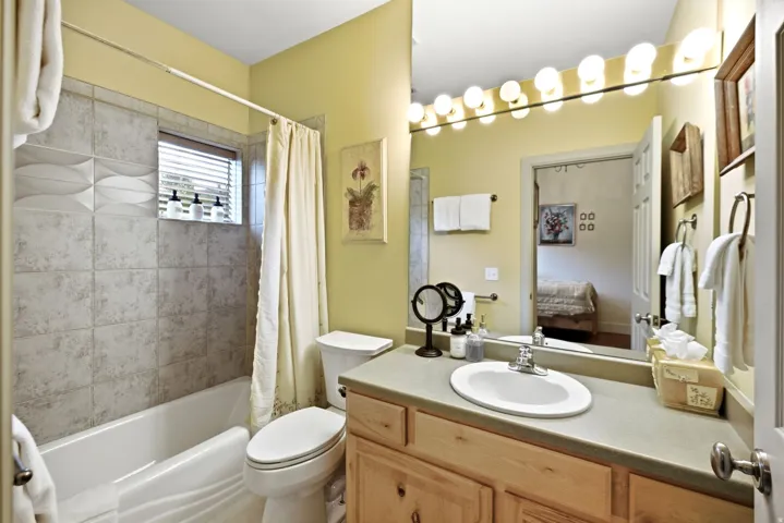 Bathroom featuring a full vanity with an integrated sink, a large mirror, and a wall-mounted light bar