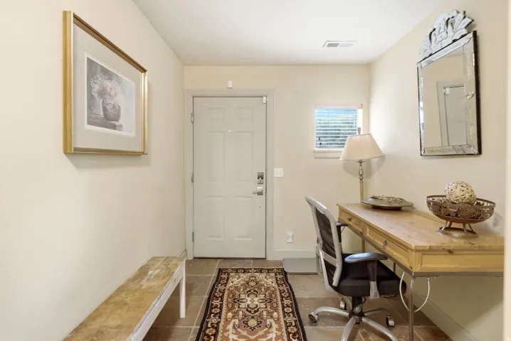Entry foyer with stone tile flooring and a paneled door