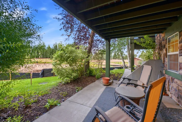 Covered patio featuring a concrete slab and stone veneer exterior