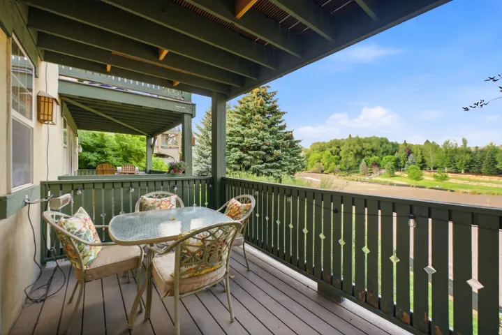 Outdoor deck featuring composite decking, painted wood railing with decorative cutouts, and an exterior wall light fixture