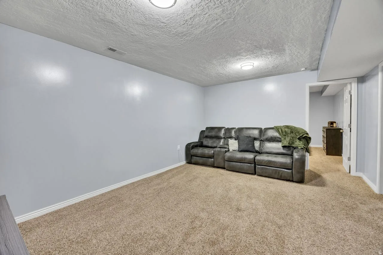 Carpeted room with light blue walls and white baseboards