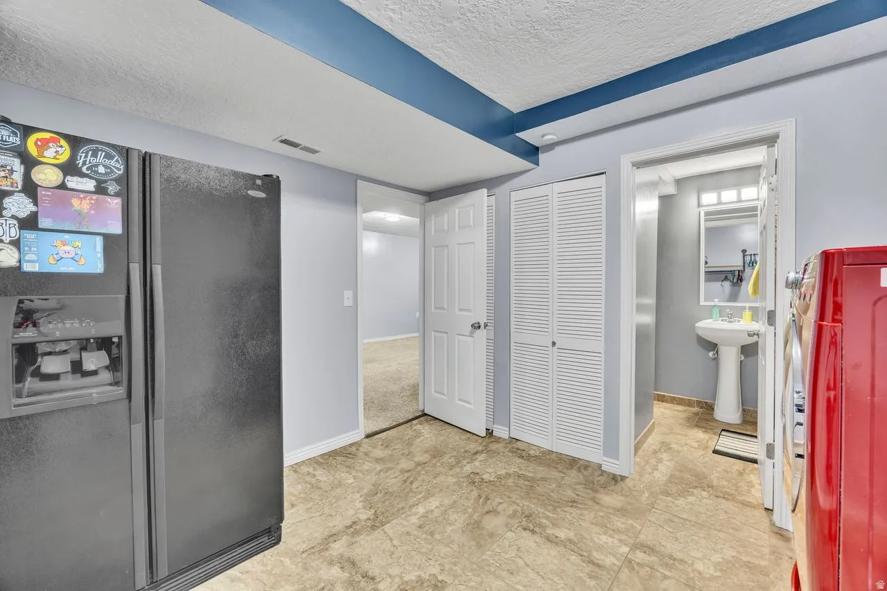 Pedestal sink in a tiled bathroom with a rectangular mirror and overhead lighting