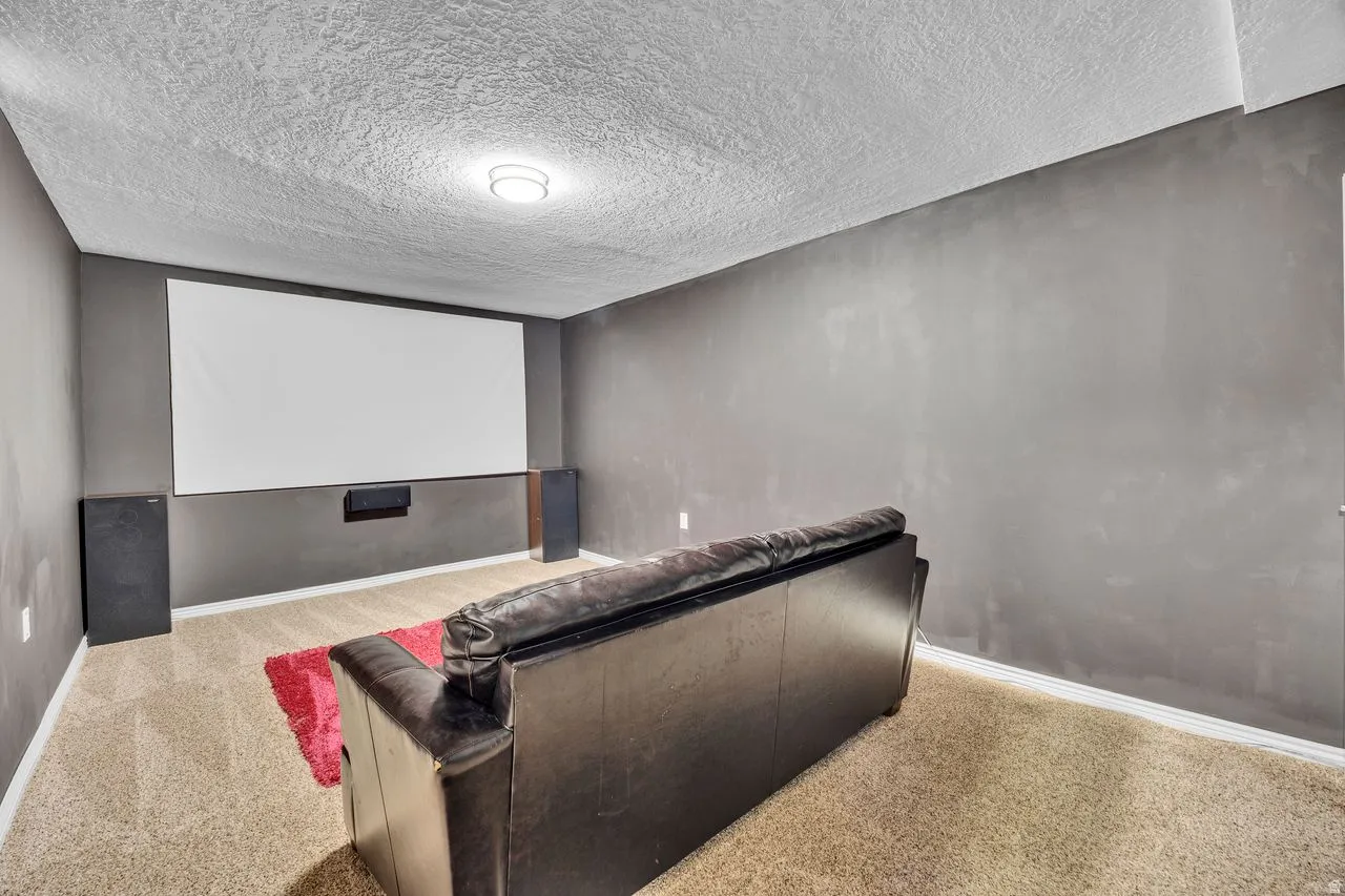 Dedicated media room featuring a large projection screen and dark wall finishes