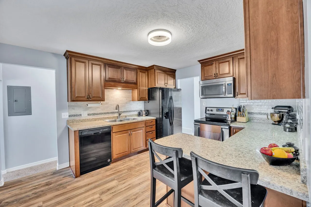 Functional kitchen featuring wood-finish cabinetry, light-toned countertops, and stainless steel appliances