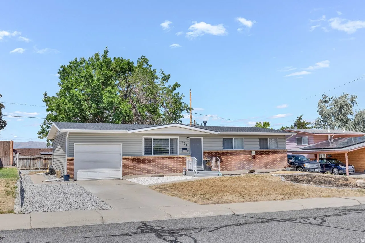 Ranch-style exterior with a combination of brick and siding, featuring an attached garage with a white door