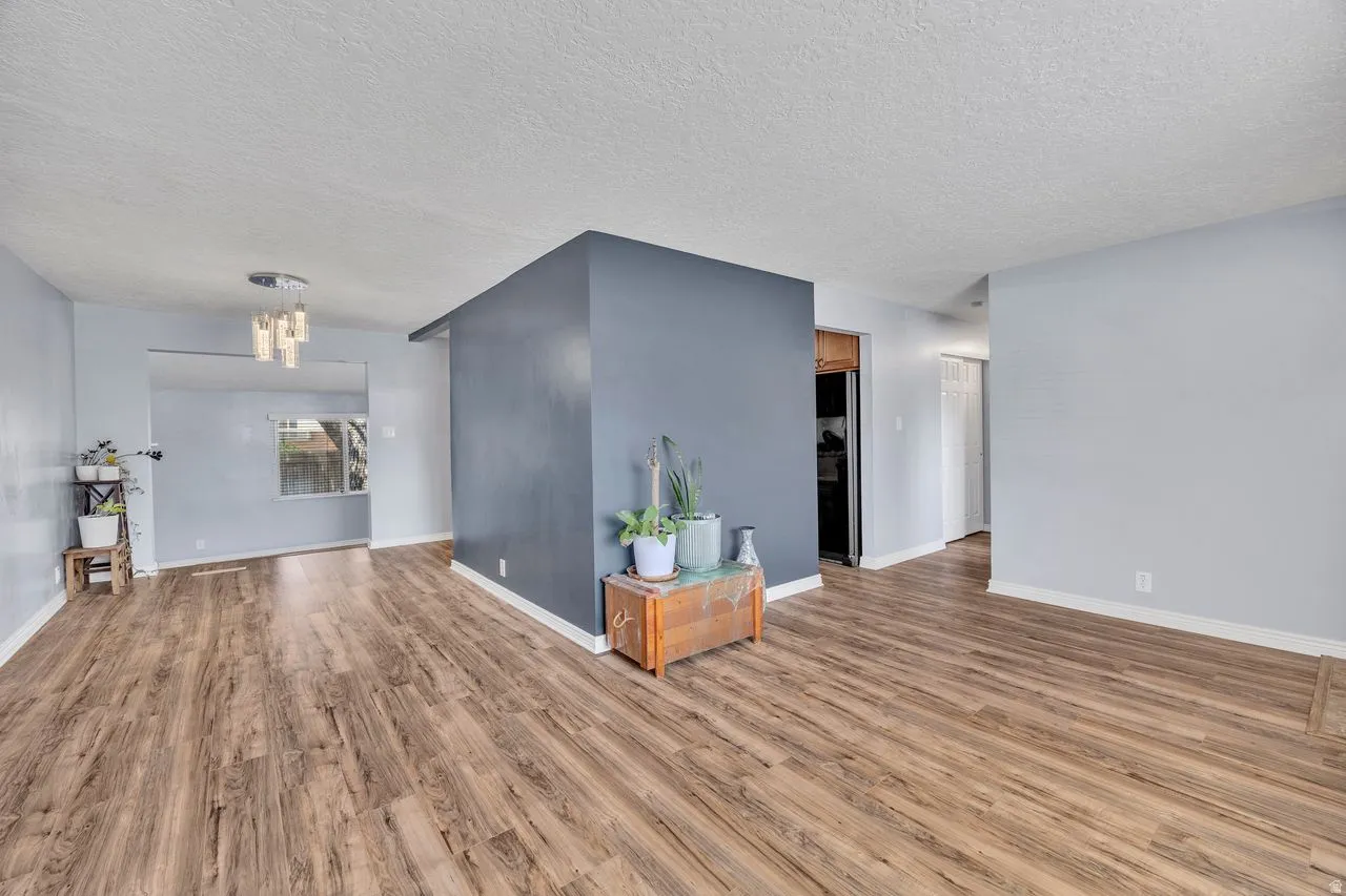 Spacious interior featuring wood-finish flooring, light grey walls, and a recessed window