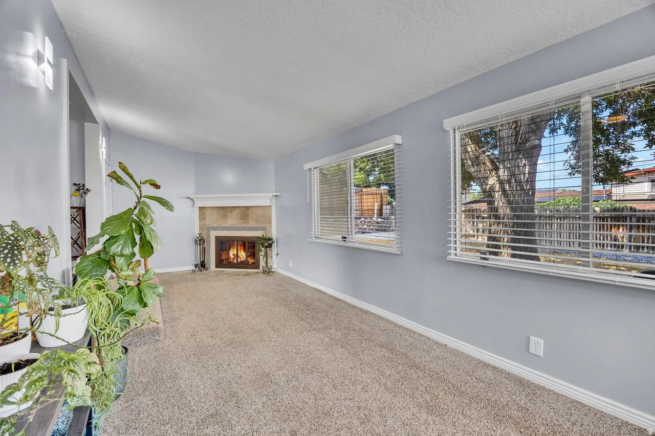 Living area featuring a fireplace with a stone surround and a white mantel