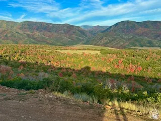 Expansive mountain landscape featuring varied terrain and a prominent blue sky