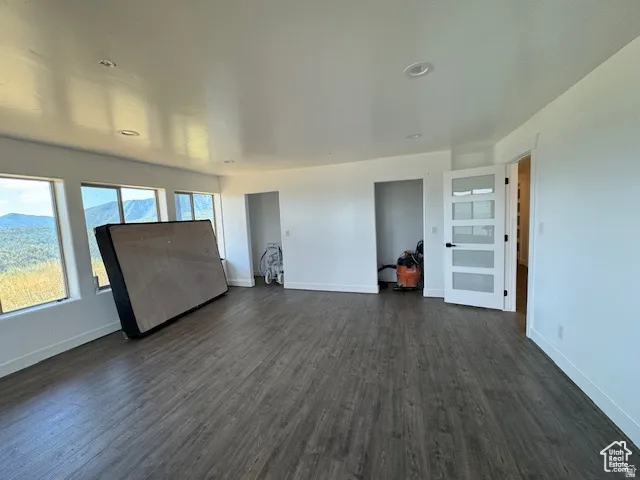 Spacious room featuring wood-finish flooring, recessed lighting, and multiple windows