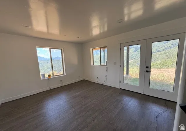 Spacious room featuring wood-finish flooring, recessed lighting, and white baseboards