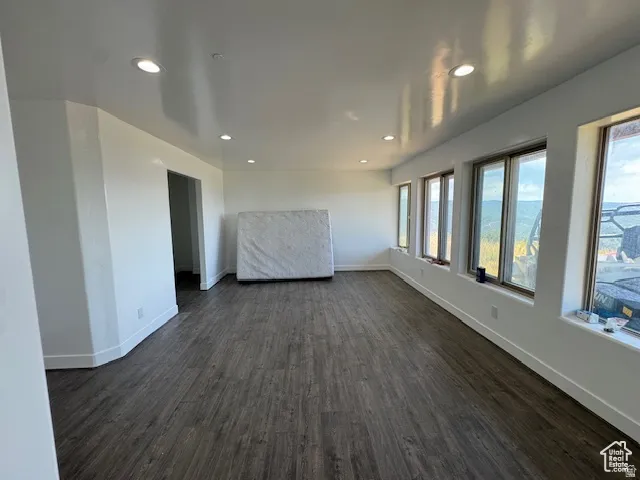 Spacious interior room featuring wood-finish flooring and recessed lighting