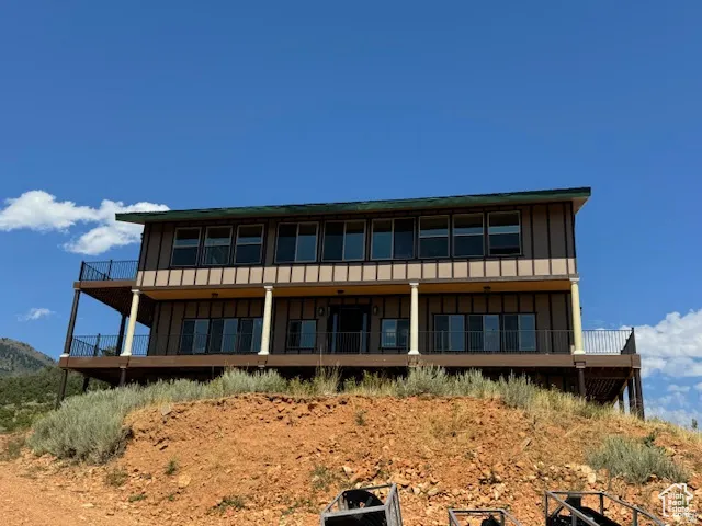 Two-story residence featuring extensive decking, numerous windows, and multiple sliding glass doors
