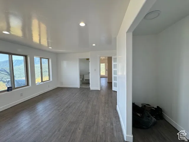 Spacious interior featuring wood-finish flooring, recessed lighting, and white baseboards