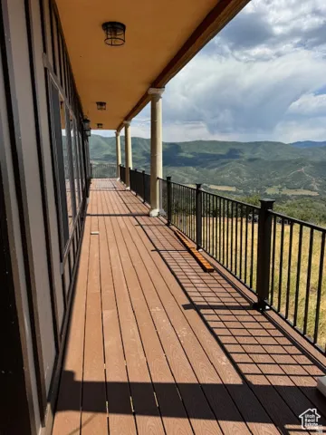 Expansive outdoor deck featuring wood-finish flooring and a black metal railing