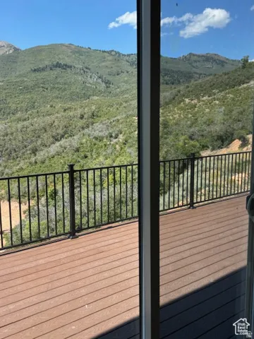 Expansive outdoor deck with composite decking and black metal railing, offering broad views of mountainous terrain