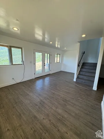 Spacious room featuring wood-finish flooring, recessed lighting, and white walls