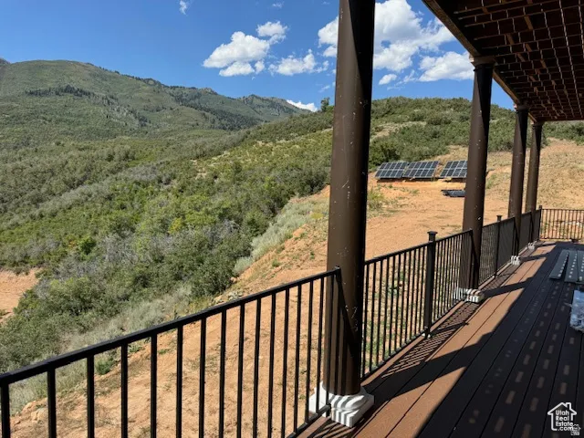 Expansive outdoor deck featuring composite decking, dark metal railings, and decorative columns