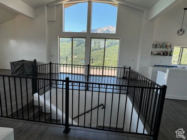 Open-concept upper level featuring vaulted ceilings, floor-to-ceiling windows, and wood-finish flooring
