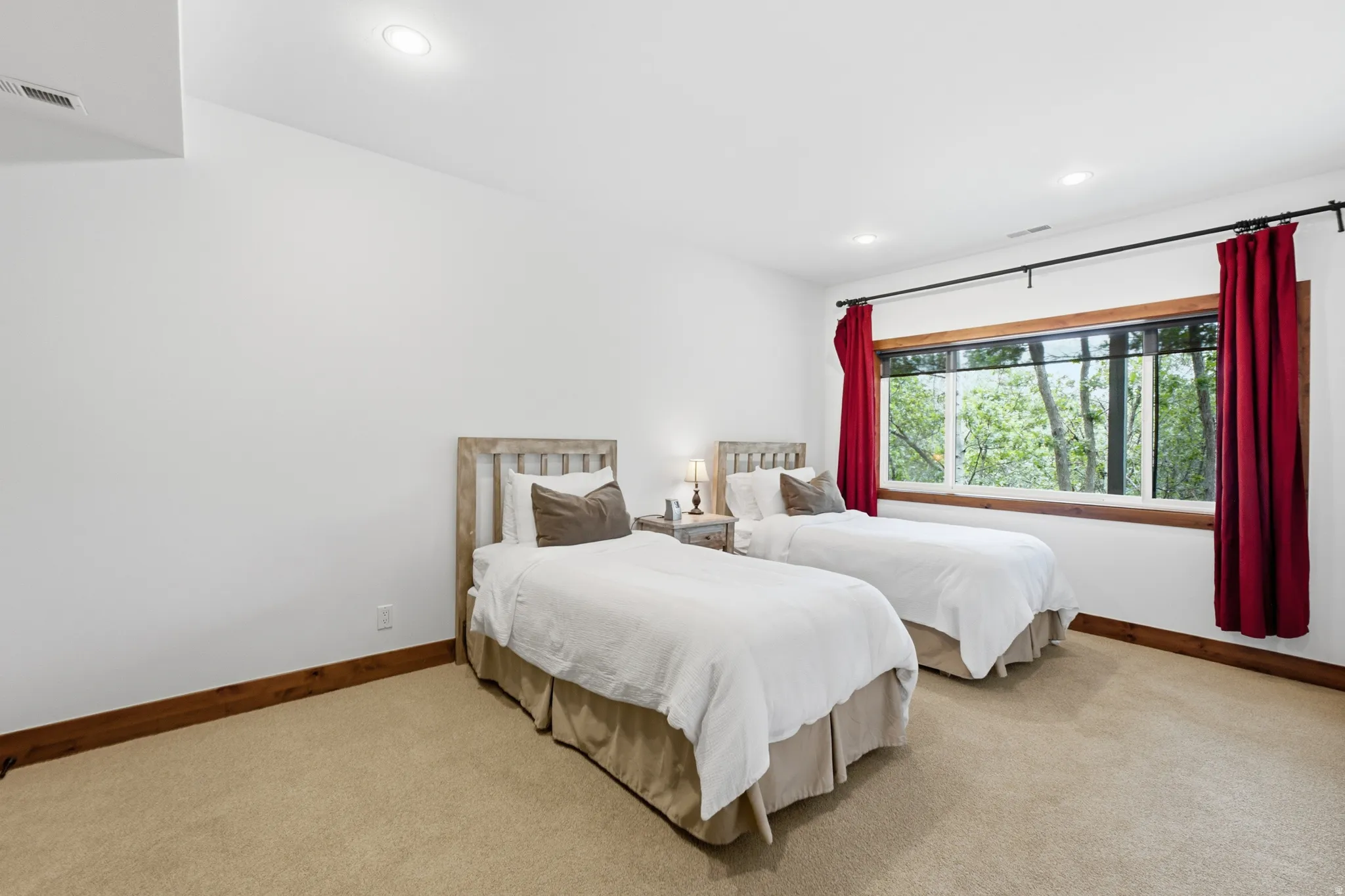 Bedroom featuring a large multi-pane window, recessed lighting, wood trim, and carpeted flooring