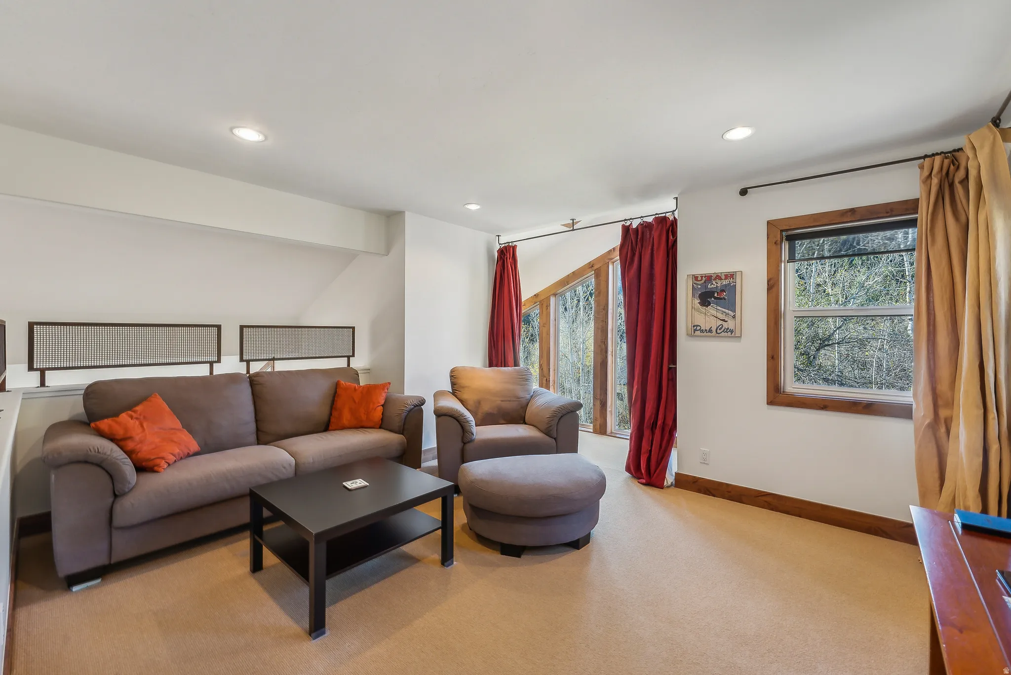Living area featuring recessed lighting, a window with natural wood trim, and a high window with natural wood trim
