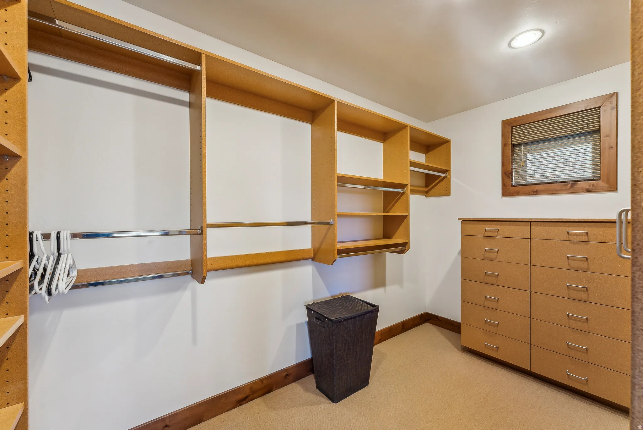 Custom closet system featuring built-in shelving, hanging rods, and a large dresser with multiple drawers