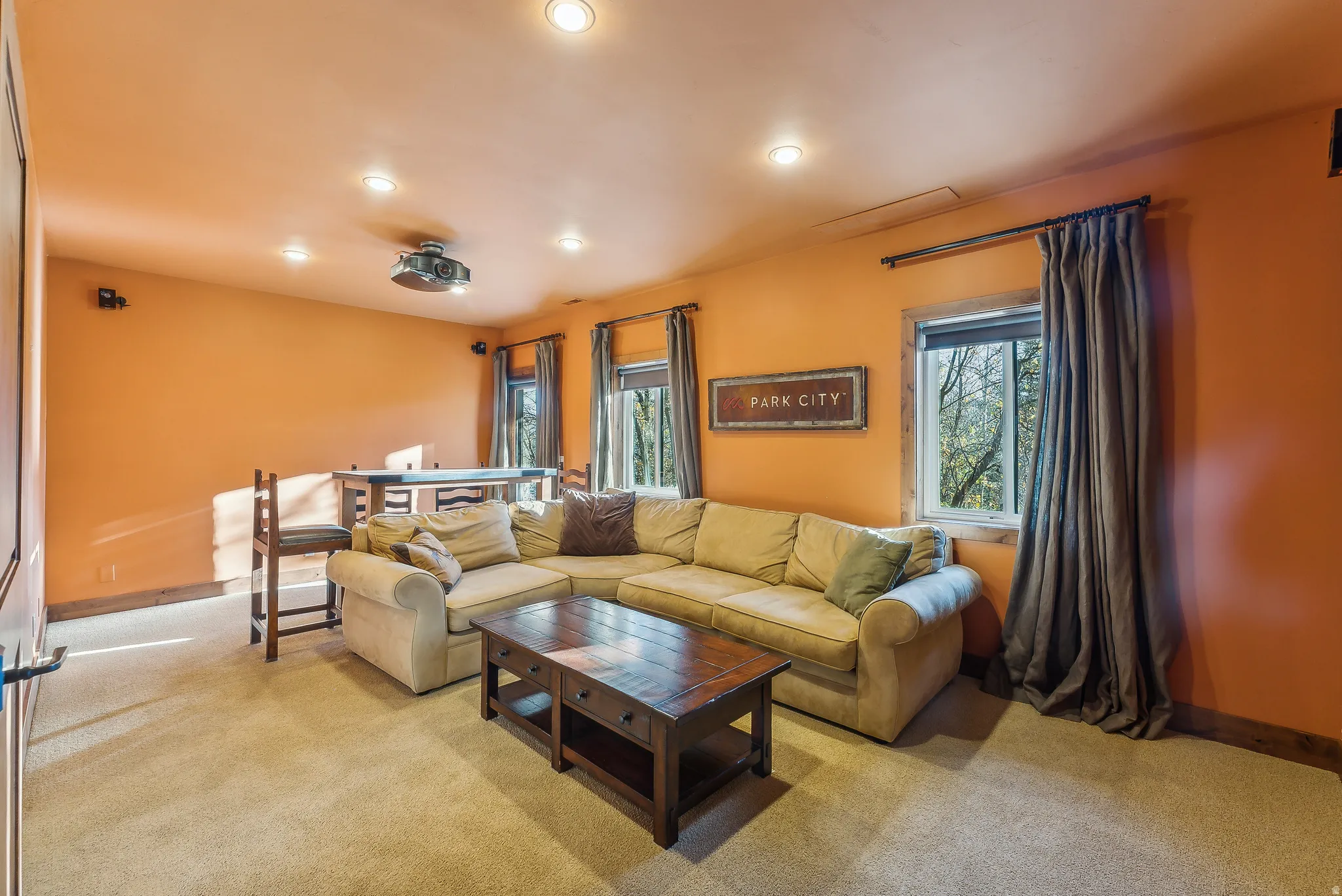 Entertainment room featuring recessed lighting, a ceiling-mounted projector, and built-in speakers